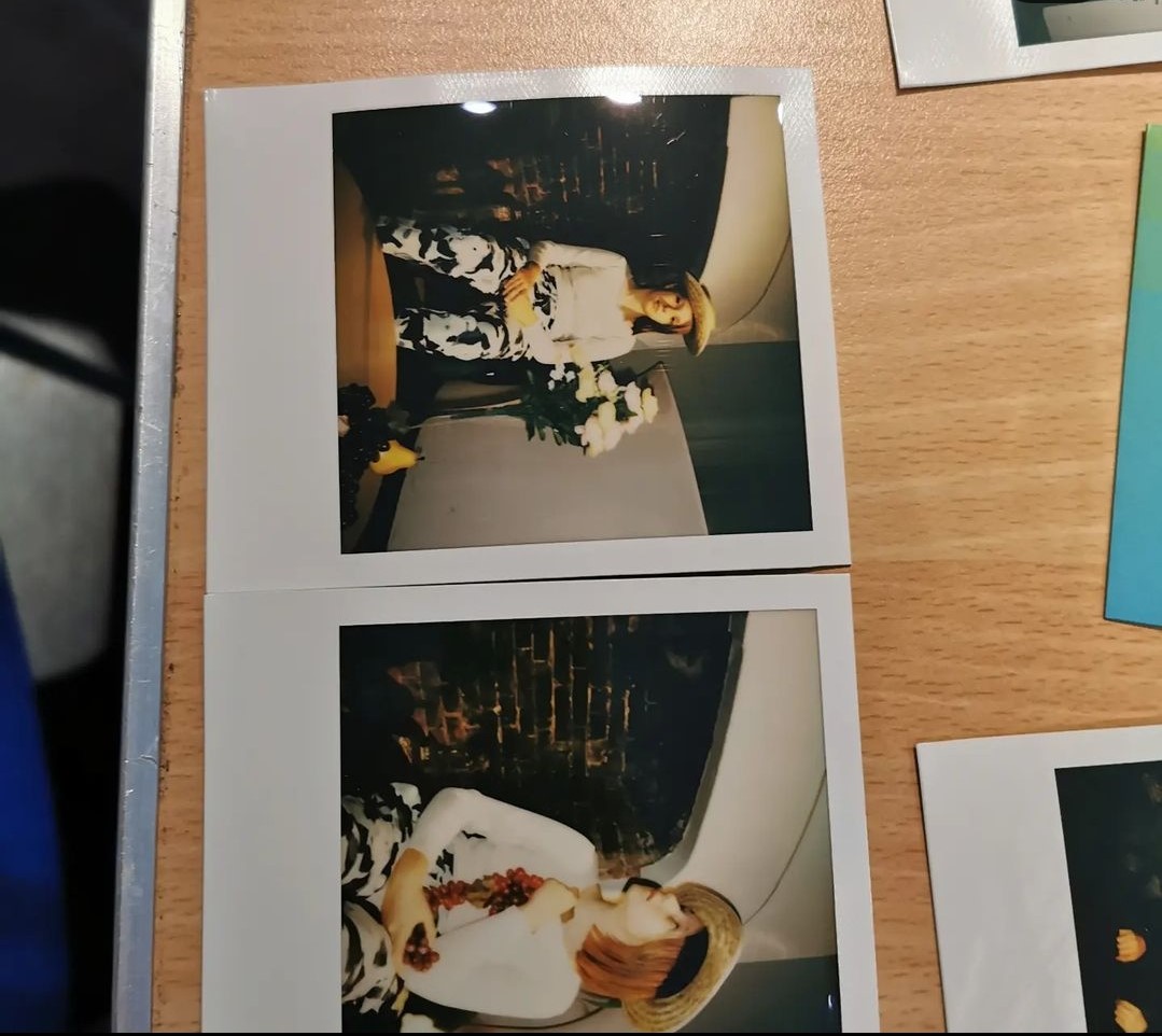 There are to square polaroid photographs taken on the day, of a young teenager posing in a hat with flowers.
